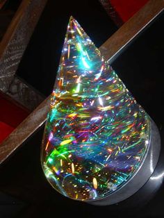 a glass christmas tree sitting on top of a metal stand