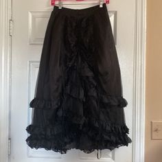 New With Tags Purchased In 2011 For A Halloween Costume Party And Never Wore It’s Been In Storage Ever Since Rq-Bl Red Queens Black Legion Polyester Multi Tier Skirt Pull On Style Elastic Waist High Low Hem Size F Will Fit One Size It’s All Size Small To Large Measurements Waist 12” Flat Across And 18” Max Stretched Length 29” Height 34” Low In Preowned Condition Black Costume Skirt With Attached Cancan, Black Skirt With Attached Cancan For Costume, Black Long Ruffled Skirt Petticoat, Black Long Ruffled Petticoat, Ruffled Tiered Skirt For Costume Party, Fitted Black Long Petticoat, Gothic Black Skirt With Attached Cancan, Black Skirt With Attached Cancan For Costume Party, Black Long Skirt With Ruffles