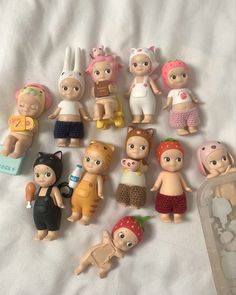 a bunch of small toy figurines sitting on top of a white bed sheet