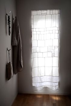 an empty room with two towels hanging on the wall and a window in the corner