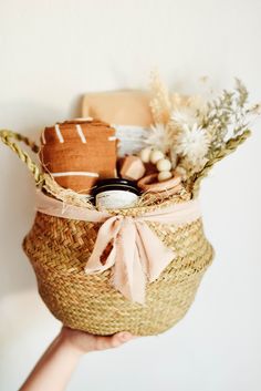 a person holding a basket with items in it and some other things on the inside