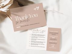 two business cards on top of a bed with white sheets and flowers in the background