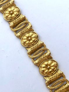 Beautiful Etruscan Egyptian Revival style bracelet in a rich golden color. The piece is high end, featuring an intricate floral design. It measures about 7.5 and weighs about 54.4g! Beautiful vintage condition and stamped both Trifari and Saltz on the back.  I have the matching earrings separately listed as well. See the last photo for an image of the set. Please see all photos and ask any questions. All items sold as found from estates and my own personal family collection. Thank you for shoppi Luxury Ceremonial Jewelry With Motifs, Luxury Brown Hand-tooled Jewelry, Luxury Ornate Gold Plated Jewelry, Cheap Gold Antique Finish Jewelry, Luxury Antique Finish Jewelry For Wedding, Luxury Hand Set Festive Sets, Luxury Antique Gold-tone Jewelry, Luxury Antique Jewelry For Festive Season, Luxury Heirloom Bronze Jewelry