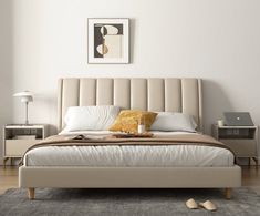 a bedroom with a bed, nightstands and pictures on the wall above it in neutral colors