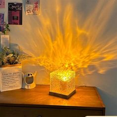 a lamp that is sitting on top of a wooden table in front of a wall