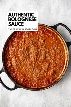 a skillet filled with chili sauce on top of a white counter next to a sign that says authentic bolognaese sauce