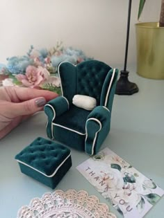 a miniature chair and footstool are sitting on a table next to doily