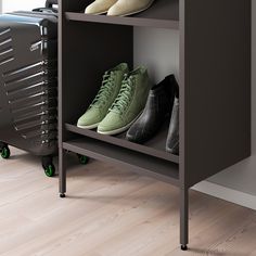 three pairs of shoes are sitting on a shelf in front of a luggage bag and suitcase