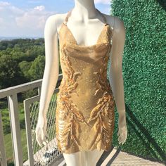 Be The Showstopper In This Dazzling, One Of A Kind Gold Embellished Chain Dress With Plunge Back, Perforated Side Slits And Crystal Appliqus. Glamorous Halter Neck Embellished Dress, Glamorous Embellished Halter Neck Dress, Gold Halter Neck Sequined Dress, Evening Embellished Backless Sequin Dress, Elegant Embellished Backless Cocktail Dress, Gold Sequined Mini Dress For Evening Wear, Backless Embellished Mini Dress For Prom, Evening Sequin Mini Dress With Beaded Straps, Evening Mini Sequin Dress With Beaded Straps