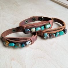 Genuine chunks of African Turquoise is sewn on to a genuine leather cuff with two adjustable snaps. Please note, all stones are genuine. They come in a variety of shapes and colors shown in multiple pictures. Entire length of bracelet is 3/4" by 9" Adjusts with snaps from Approx. 7.25" to 7.75" Although your bracelet will resemble the photo, each piece is created by hand, so no two are identical.Thank you for visiting The Jewelry Junkie! Leather Cuff Bracelet Diy, Leather Accessories Diy, Cuff Bracelets Diy, Leather Bracelet Tutorial, Diy Leather Bracelet, Dyi Jewelry, Diy Slippers, Multiple Pictures, Cord Jewelry