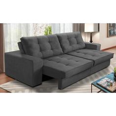 a gray couch sitting on top of a rug in a living room