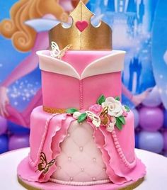 a pink princess cake with a gold crown on top