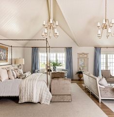 a large bedroom with white walls and blue curtains on the windowsills is decorated in neutral tones