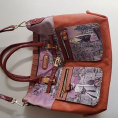 an orange and pink purse with multiple zippers on the front, two inside pockets