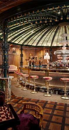 the inside of a restaurant with tables, chairs and a large chandelier above it