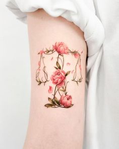 a woman's thigh with pink flowers on it and leaves around the thighs,