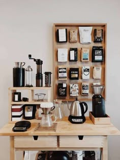 a wooden table topped with lots of different types of coffee accessories and items on shelves