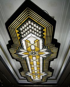 the ceiling is decorated with gold and white art deco style decorations, including an intricate cross