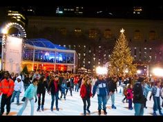 people skating on an ice rink in front of a large christmas tree at night time