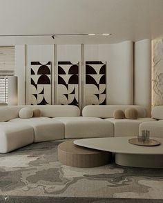 a modern living room with white furniture and art work on the wall behind the couch