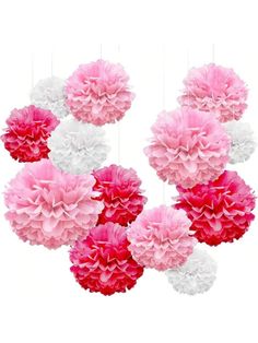 pink and white tissue pom poms hanging from strings