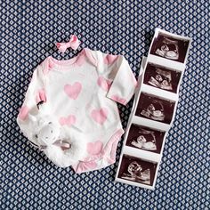 a baby's bodysuit and its matching onesuit are laid out on a bed