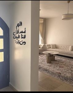 a living room filled with furniture and a blue door in front of a white wall