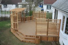 a wooden deck in the middle of a yard