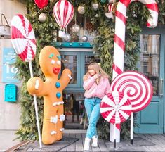 a woman sitting next to giant candy canes and gingerbread man