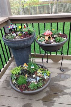 two potted plants are sitting on the porch with little fairy houses and mushrooms in them