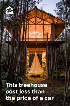 a tree house in the middle of some trees with a white net hanging from it's roof