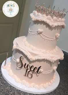 a three tiered cake with the word suce on top and a crown atop it