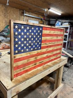 an american flag made out of wood sitting on top of a workbench in a garage