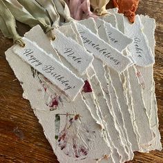 several pieces of paper with writing on them sitting on a wooden table next to other items