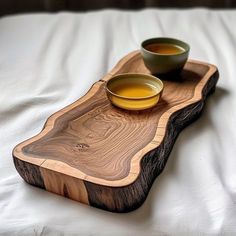 two bowls are sitting on a wooden tray