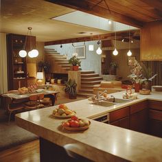 a kitchen filled with lots of counter top space next to a living room and dining area