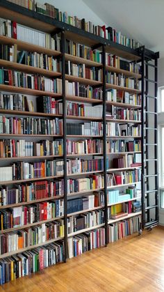 a large bookcase filled with lots of books on top of a hard wood floor