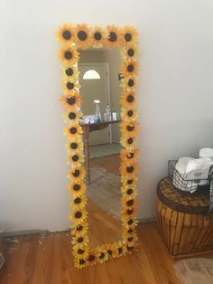 a sunflower decorated mirror in the corner of a room