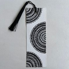 a black and white bookmark with a tassel hanging from it's side