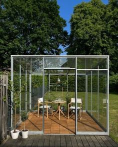 a glass house sitting on top of a wooden deck