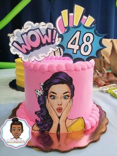 a pink cake with an image of a woman on the top and now 48 sign above it