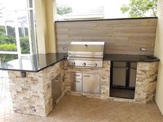 an outdoor kitchen with grill and sink