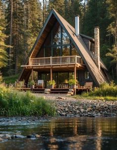 a - frame cabin on the shore of a river