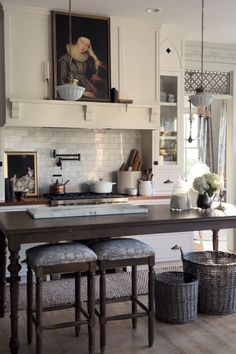 a kitchen with two stools and a table in front of the stove top oven