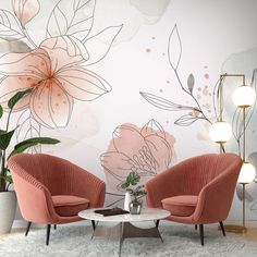 two chairs and a table in front of a wall with flowers on it