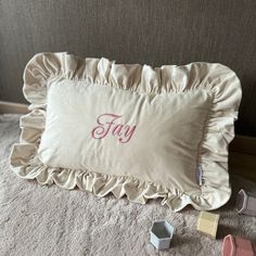 a pillow with the word faly on it next to some other items that are scattered around