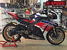 a red, white and blue motorcycle in a shop