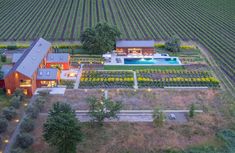 an aerial view of a farm house with a swimming pool in the middle of it