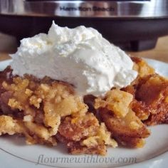 two scoops of ice cream sit on top of a piece of apple crisp pie