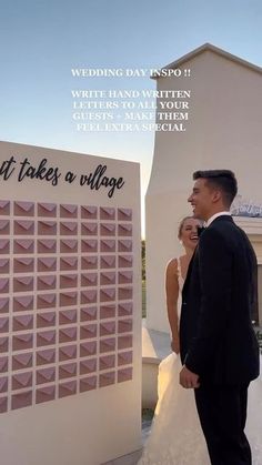 a man and woman standing in front of a sign that says it takes a village